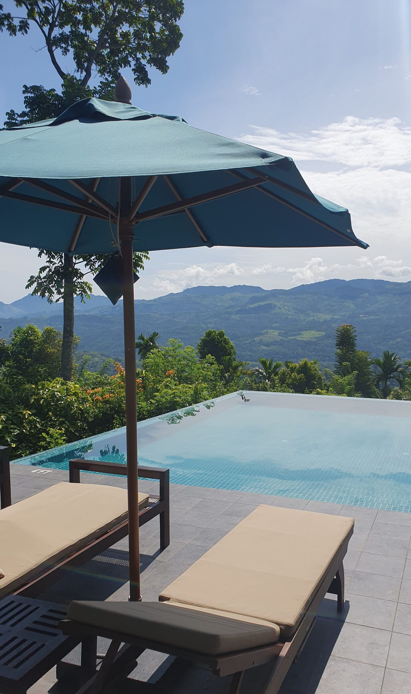 Two sunbeds at the edge of Aarunya’s infinity pool overlooking the Knuckles Mountains