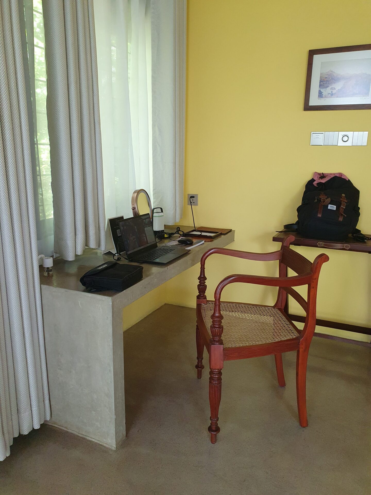 Minimalist concrete desk with a wooden chair in a villa at Aarunya, blending modern lines with natural textures