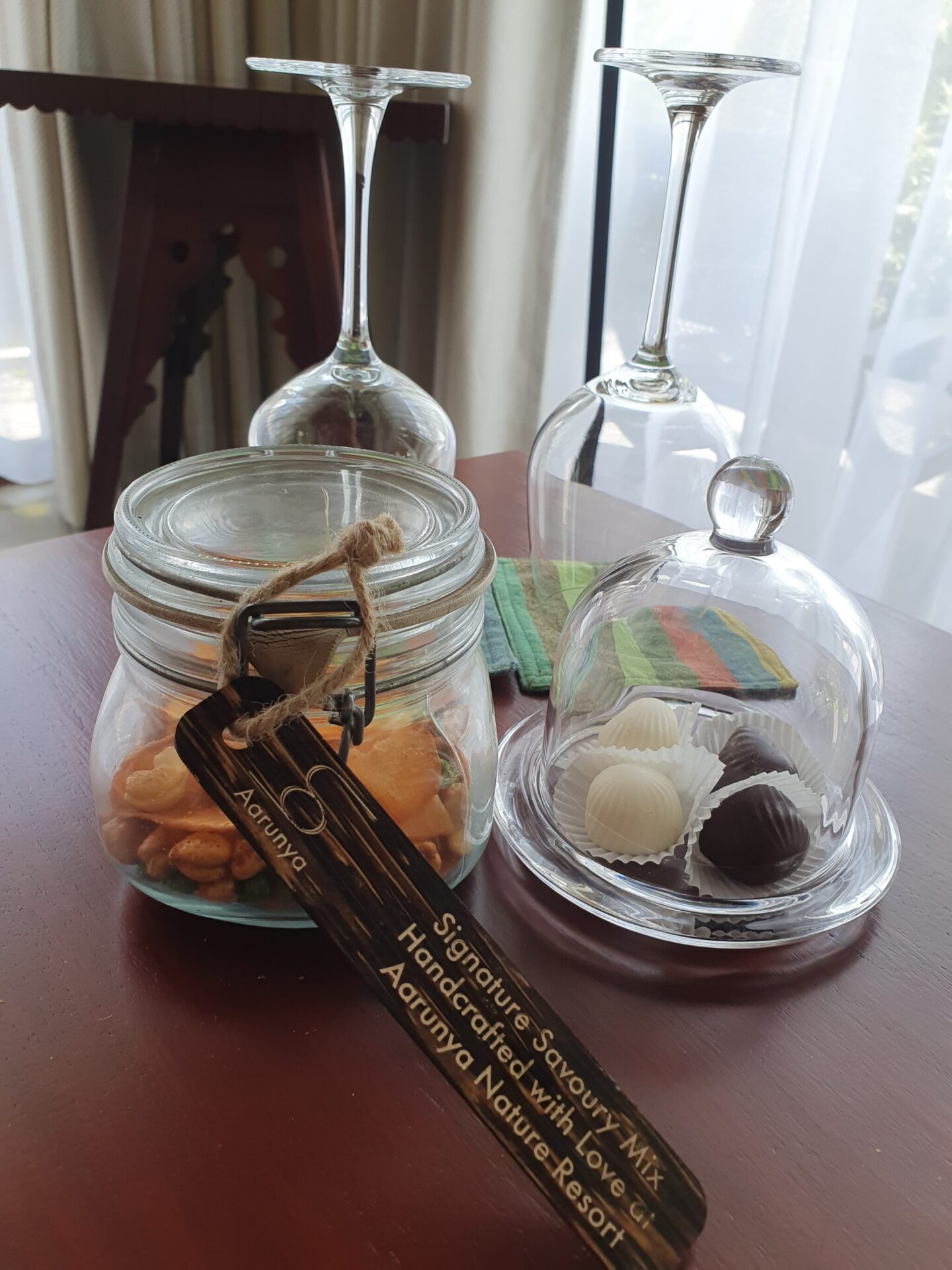 Homemade welcome snacks at Aarunya under glass domes with handwritten ingredient labels