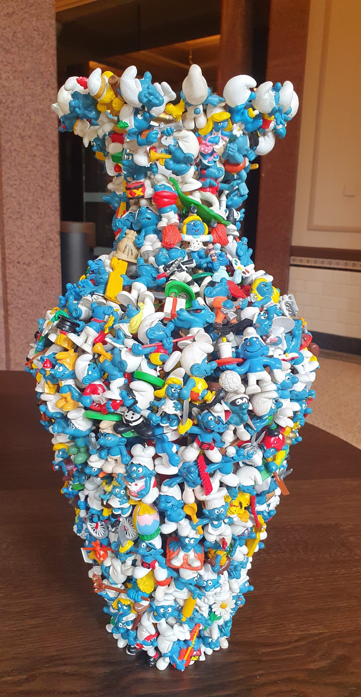 Quirky art piece at Rosewood Amsterdam: a vase constructed entirely from blue Smurf figurines